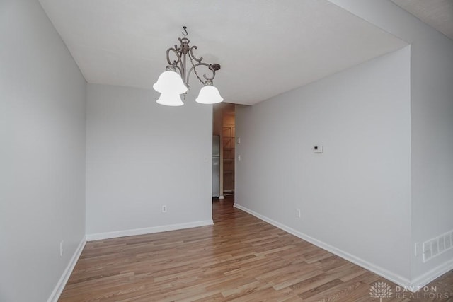 7616 Pons Ln, West Chester, OH 45069 - empty room featuring light wood-style floors, a chandelier, and baseboards