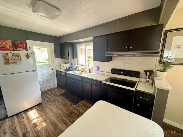 4065 Locustwood Dr, Dayton, OH 45429 - kitchen with white appliances, a sink, dark wood finished floors, under cabinet range hood, and decorative backsplash