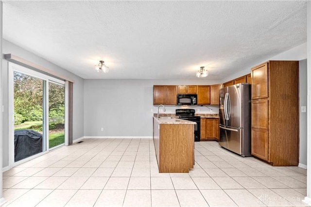 5065 Cross Creek Ln, Miami Township, OH 45150 - kitchen featuring black appliances, baseboards, brown cabinetry, a textured ceiling, and light tile patterned floors