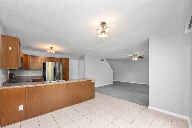 5065 Cross Creek Ln, Miami Township, OH 45150 - kitchen with stainless steel appliances, brown cabinets, a peninsula, a ceiling fan, and light colored carpet