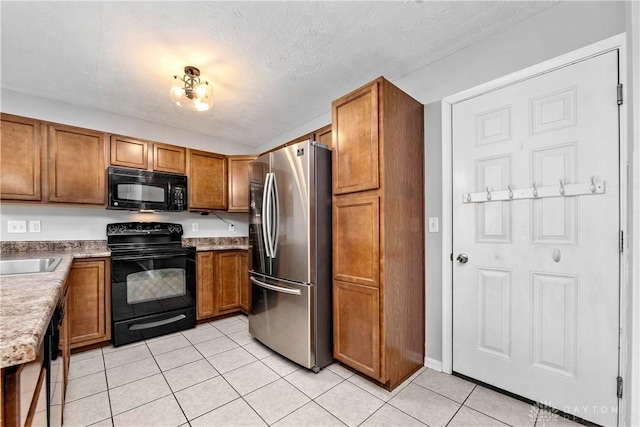 5065 Cross Creek Ln, Miami Township, OH 45150 - kitchen featuring black appliances, brown cabinetry, light tile patterned flooring, and a textured ceiling