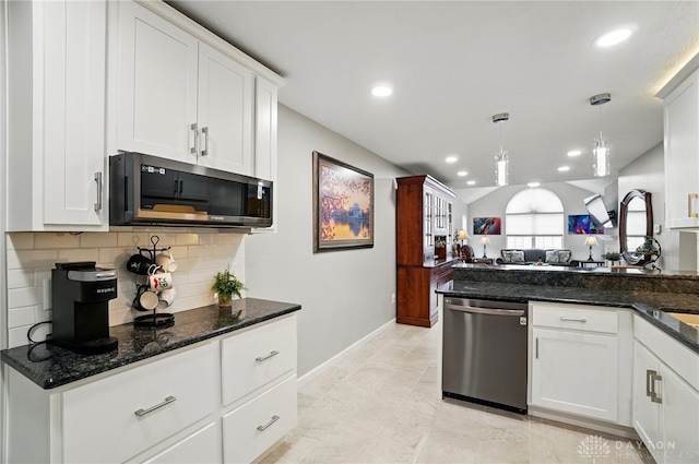 kitchen featuring appliances with stainless steel finishes, open floor plan, decorative backsplash, white cabinetry, and baseboards