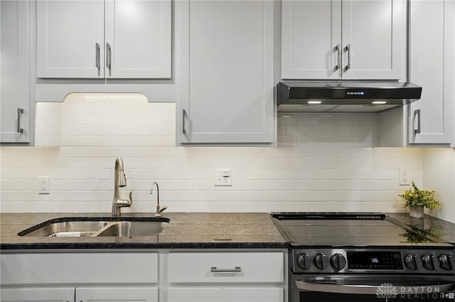 kitchen featuring range with electric cooktop, a sink, under cabinet range hood, backsplash, and white cabinetry