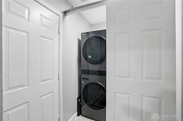 clothes washing area featuring stacked washing machine and dryer