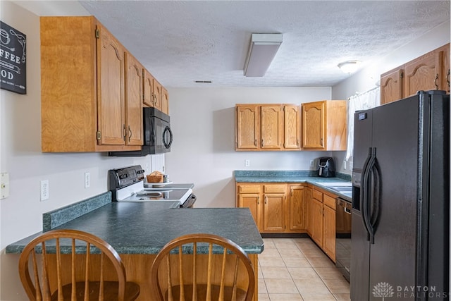 82 Choctaw Cir, Franklin, OH 45005 - kitchen with black appliances, a peninsula, a textured ceiling, light tile patterned floors, and dark countertops