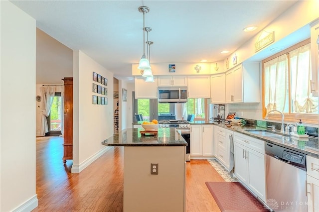 849 Wind Blf, Springboro, OH 45066 - kitchen with appliances with stainless steel finishes, a center island, dark stone countertops, white cabinets, and light wood-style flooring