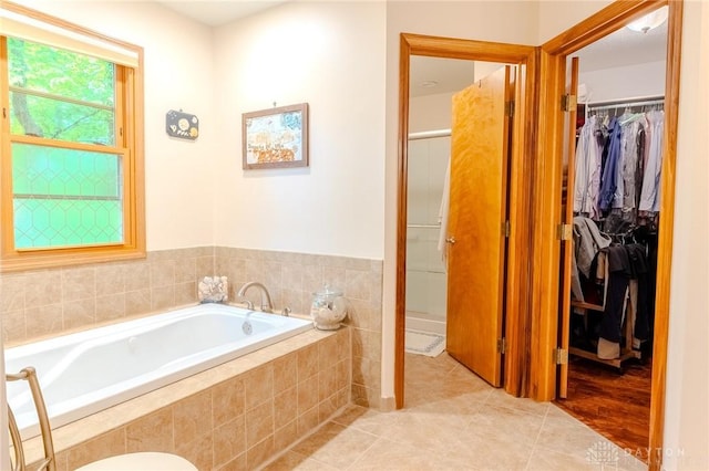 849 Wind Blf, Springboro, OH 45066 - bathroom featuring a walk in closet, a bath, tile patterned flooring, and a shower stall