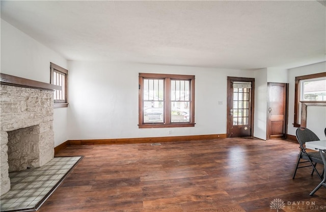 20 N 10th St, Miamisburg, OH 45342 - unfurnished living room featuring a stone fireplace, baseboards, and wood finished floors