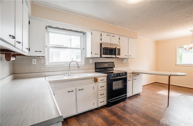 20 N 10th St, Miamisburg, OH 45342 - kitchen featuring stainless steel microwave, black range with electric stovetop, a sink, a textured ceiling, and light countertops