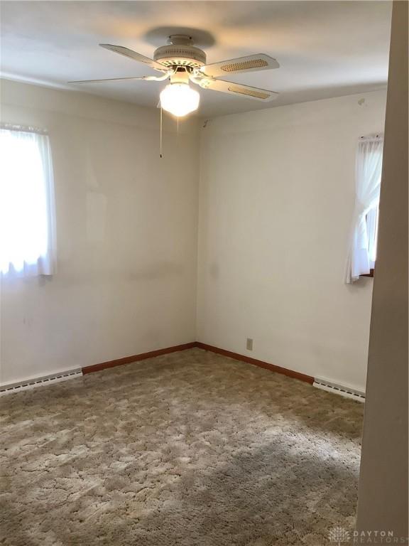 109 Anderson St, New Madison, OH 45346 - carpeted spare room with baseboard heating and a ceiling fan