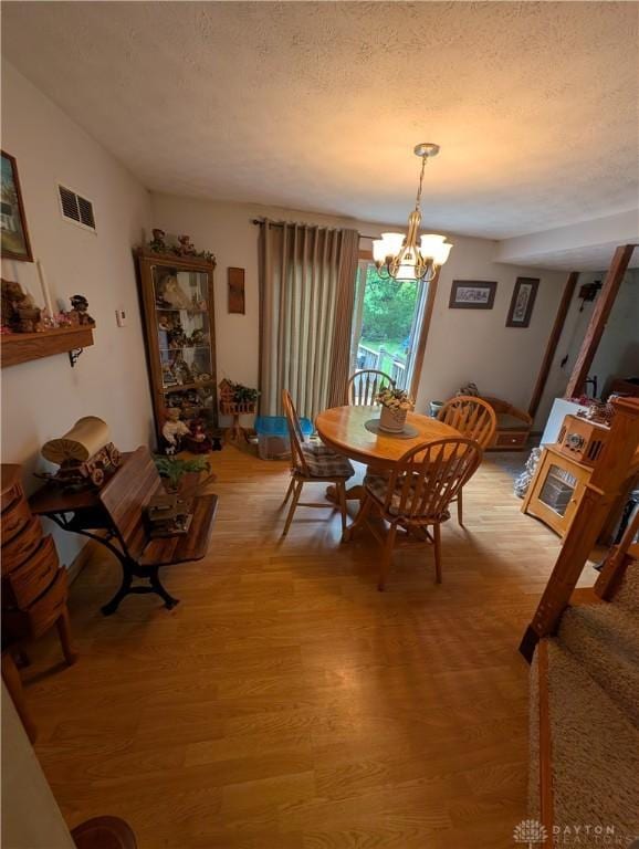 7430 S Kessler Fred Rd, West Milton, OH 45383 - dining area with light wood finished floors, a textured ceiling, and a chandelier