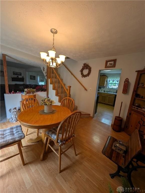 7430 S Kessler Fred Rd, West Milton, OH 45383 - dining area featuring a chandelier, light wood-type flooring, stairway, and a textured ceiling