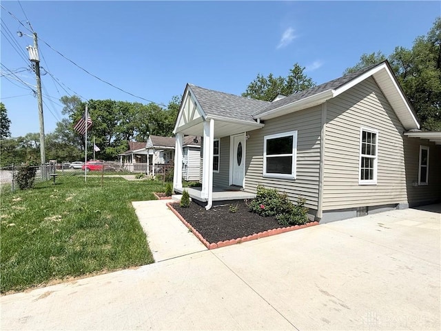 view of front of home with a porch, driveway, and roof with shingles