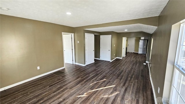 spare room with baseboards, dark wood finished floors, and recessed lighting