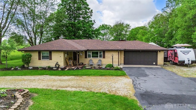 1493 N Sulphur Springs Rd, West Alexandria, OH 45381 - ranch-style home with a front yard, a garage, brick siding, and asphalt driveway