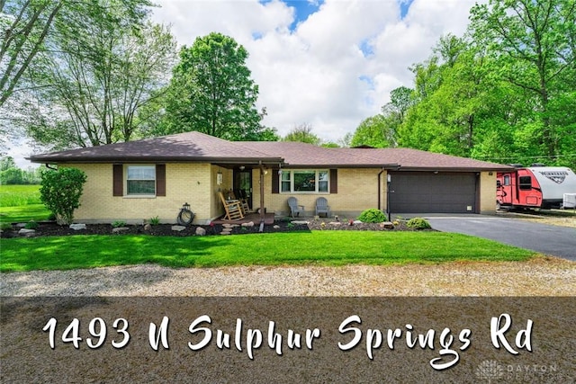 1493 N Sulphur Springs Rd, West Alexandria, OH 45381 - ranch-style house with brick siding, asphalt driveway, an attached garage, and a front lawn