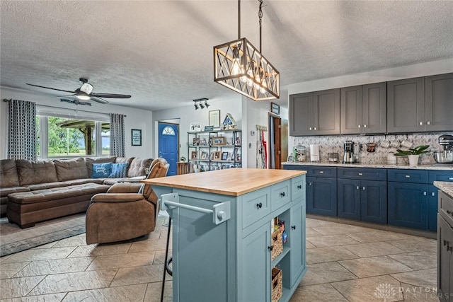 1493 N Sulphur Springs Rd, West Alexandria, OH 45381 - kitchen with open floor plan, a textured ceiling, butcher block countertops, backsplash, and ceiling fan