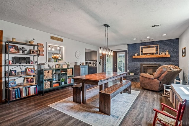 1493 N Sulphur Springs Rd, West Alexandria, OH 45381 - dining space with a textured ceiling, dark wood-type flooring, a chandelier, a brick fireplace, and recessed lighting