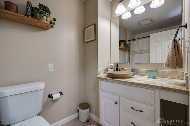 1139 Chalet Dr, New Carlisle, OH 45344 - bathroom with toilet, baseboards, vanity, and wood finished floors