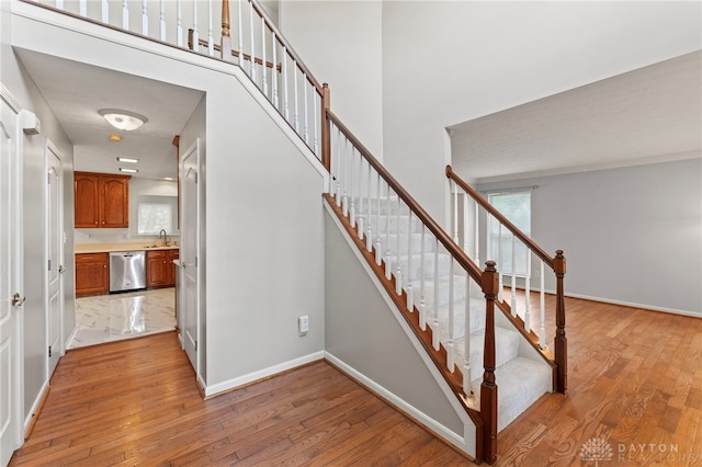 staircase with healthy amount of natural light, hardwood / wood-style flooring, and baseboards