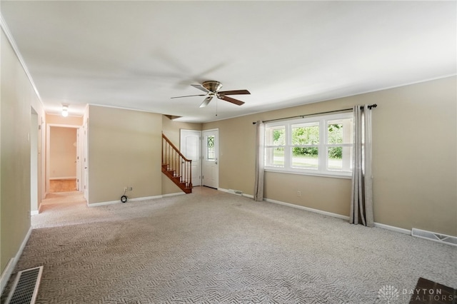 spare room featuring ceiling fan, light carpet, stairway, and baseboards