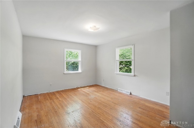 unfurnished room featuring healthy amount of natural light and light wood finished floors