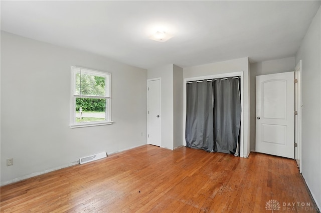 unfurnished bedroom featuring a closet and light wood-style flooring