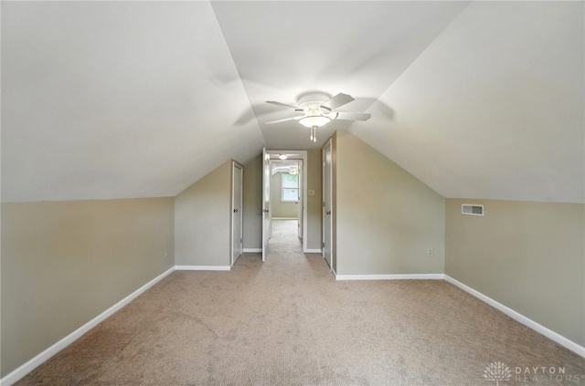 bonus room featuring ceiling fan, light carpet, baseboards, and vaulted ceiling