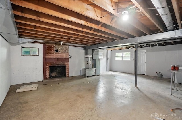 basement featuring a brick fireplace and heating unit