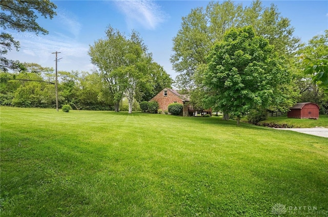 view of grassy yard with a shed and an outdoor structure