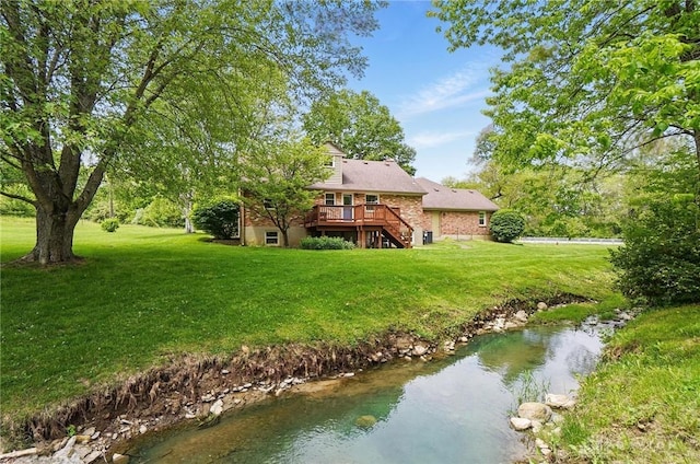 rear view of property with stairway, a wooden deck, and a yard