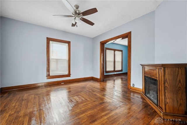 4119 Pleasant View Ave, Dayton, OH 45420 - unfurnished living room with baseboards, a glass covered fireplace, and a ceiling fan