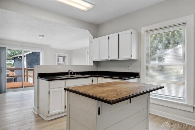 4119 Pleasant View Ave, Dayton, OH 45420 - kitchen with a sink, dark countertops, a peninsula, and white cabinetry