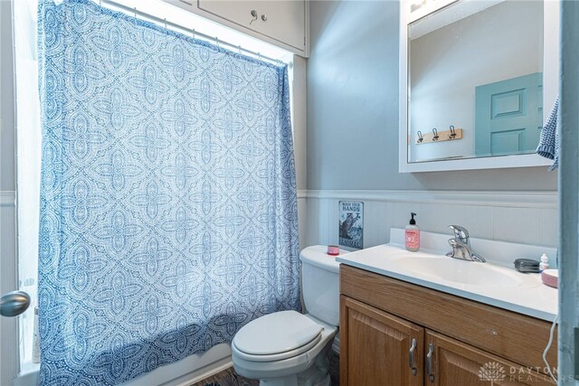 2526 Saint Charles Ave, Dayton, OH 45410 - bathroom featuring vanity, shower / bath combo with shower curtain, and a wainscoted wall