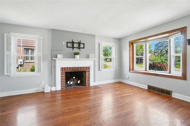 1236 Ridgeview Ave, Kettering, OH 45409 - unfurnished living room featuring wood finished floors and a brick fireplace