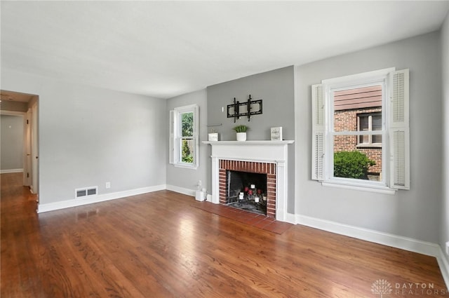 1236 Ridgeview Ave, Kettering, OH 45409 - unfurnished living room featuring a brick fireplace and wood finished floors