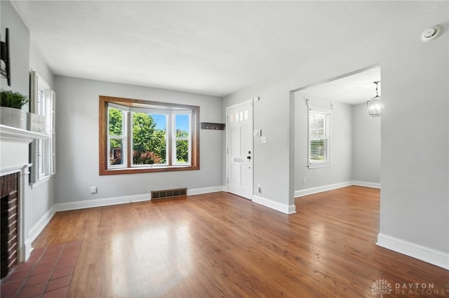 1236 Ridgeview Ave, Kettering, OH 45409 - unfurnished living room featuring healthy amount of natural light, a fireplace with flush hearth, and wood finished floors