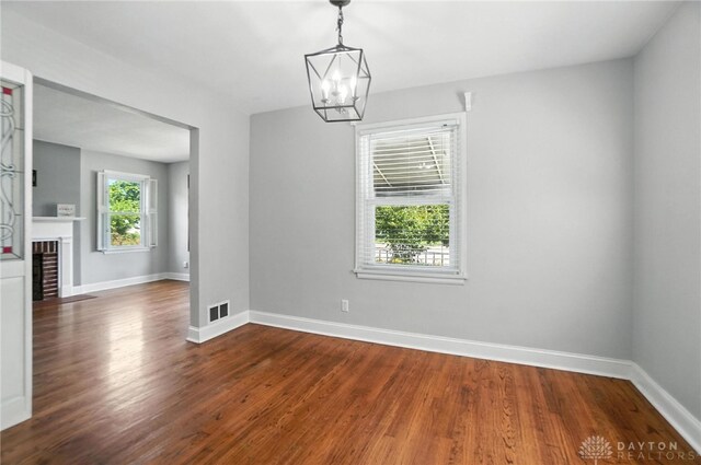 1236 Ridgeview Ave, Kettering, OH 45409 - unfurnished dining area with dark wood-style floors, a chandelier, and a brick fireplace