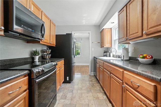1236 Ridgeview Ave, Kettering, OH 45409 - kitchen with stainless steel appliances, plenty of natural light, light stone finish flooring, and brown cabinetry