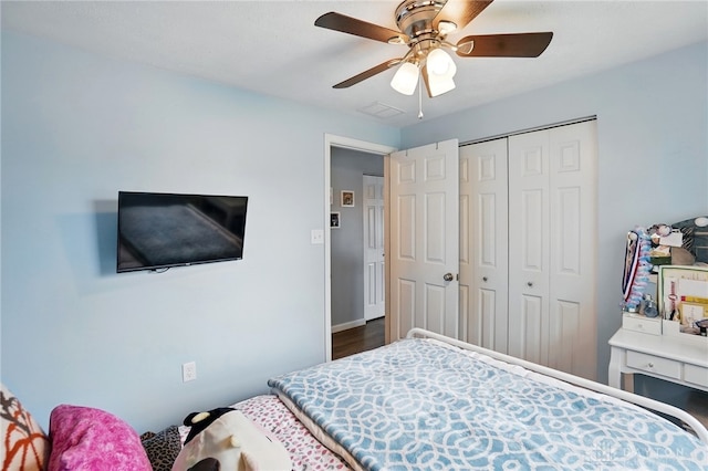 bedroom with a closet, wood finished floors, and a ceiling fan