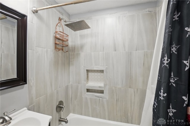 bathroom with shower / bathtub combination with curtain and a sink