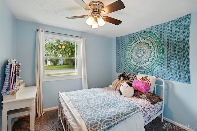 carpeted bedroom featuring baseboards and ceiling fan