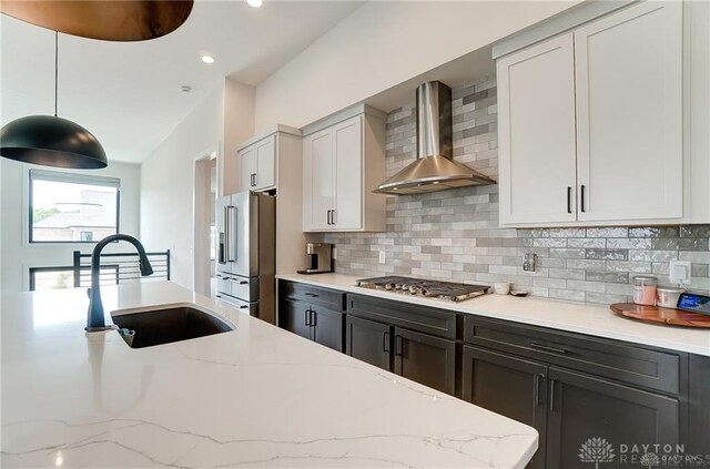 1264 Normandy, Clearcreek Twp, OH 45458 - kitchen with wall chimney range hood, appliances with stainless steel finishes, a sink, decorative backsplash, and recessed lighting