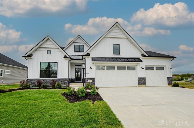 1264 Normandy, Clearcreek Twp, OH 45458 - modern farmhouse featuring stone siding, a front yard, driveway, and a standing seam roof