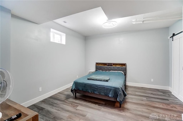 1264 Normandy, Clearcreek Twp, OH 45458 - bedroom featuring a barn door, wood finished floors, and baseboards