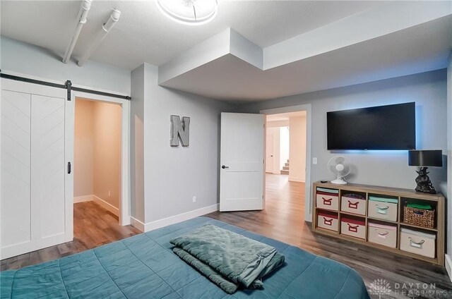 1264 Normandy, Clearcreek Twp, OH 45458 - bedroom featuring wood finished floors, a barn door, and baseboards