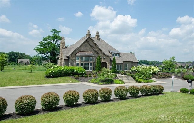 1264 Normandy, Clearcreek Twp, OH 45458 - back of property featuring stone siding, a yard, and a chimney