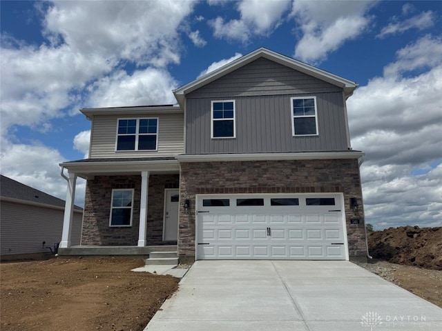 546 Hollywood Blvd, Xenia, OH 45385 - craftsman house featuring driveway, stone siding, covered porch, an attached garage, and board and batten siding