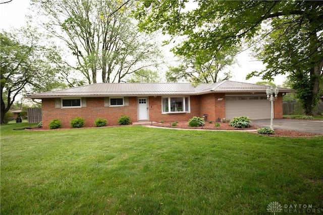 ranch-style home with driveway, a garage, brick siding, and a front lawn