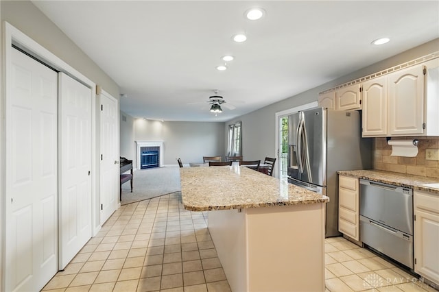 2337 Eastwind Dr, Beavercreek, OH 45434 - kitchen featuring stainless steel appliances, a center island, recessed lighting, a fireplace, and light tile patterned floors